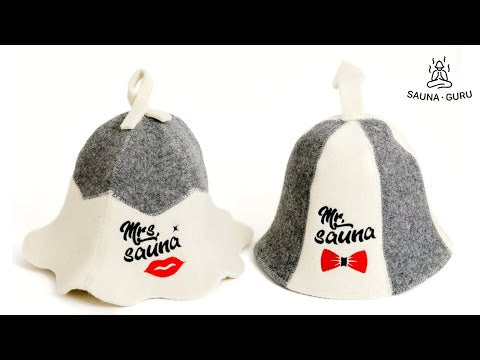 Pair of light grey and white wool sauna hats. One hat features the text 'Mrs. Sauna' and a red lips graphic. The other hat features the text 'Mr. Sauna' and a red bow tie graphic. Both hats have a loop at the top